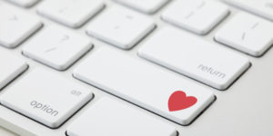 Keyboard with red heart on button, close-up
